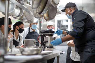 A photo of Chef Glenn Smith instructing students in the kitchen.