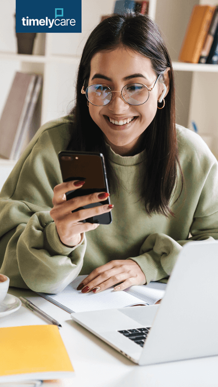 Woman sitting at a desk using her phone