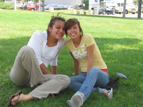 students sitting on grass outside administration building